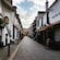 A historic cobblestone street lined with pubs, restaurants and shops